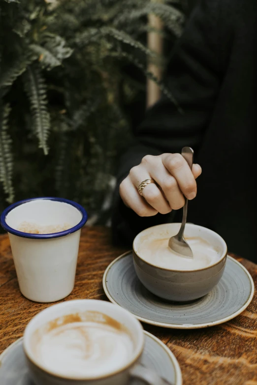 someone with their hand in the cup with a spoon