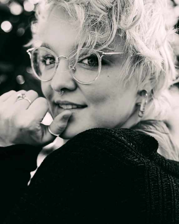 a woman wearing glasses in front of a tree