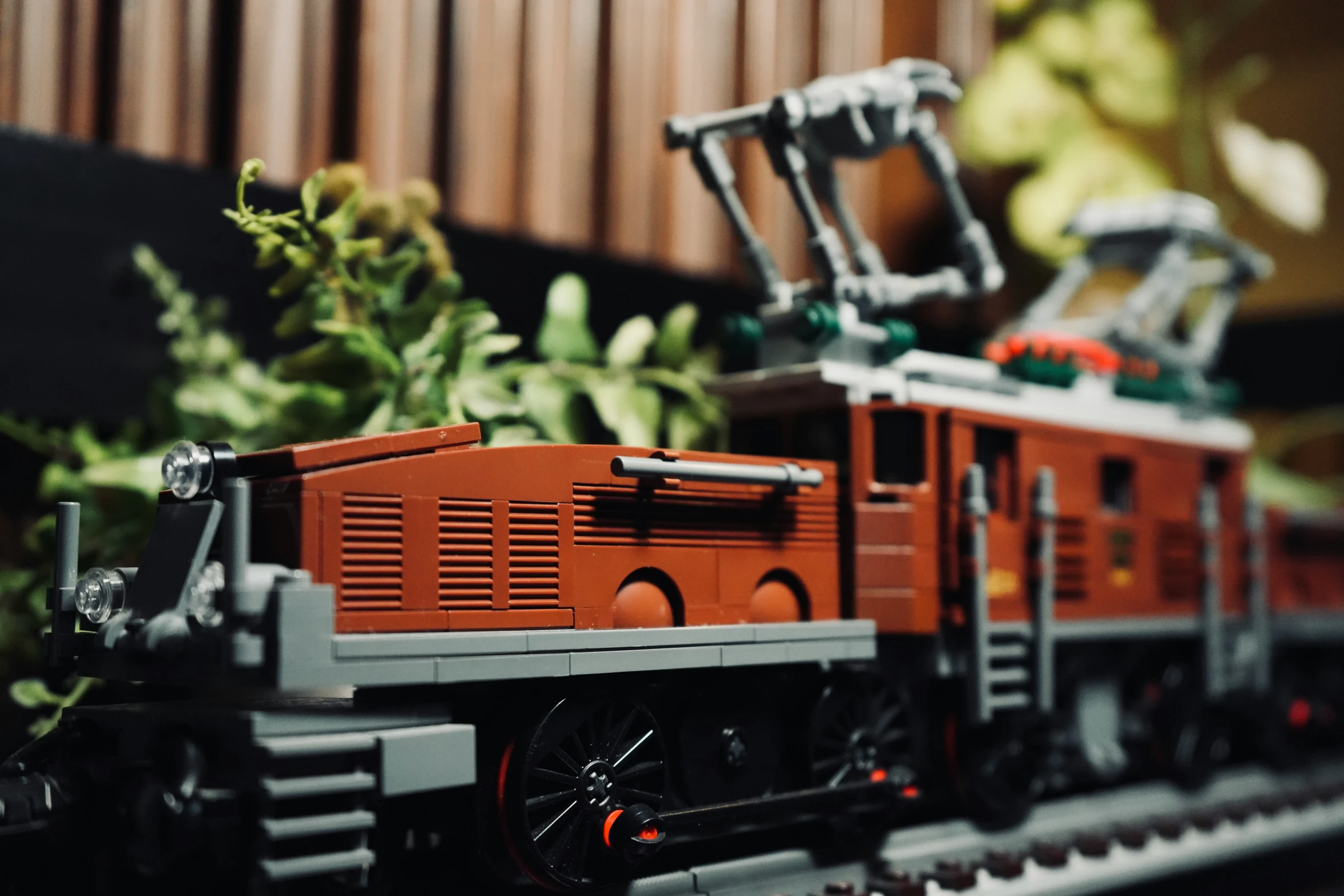 a small toy train set sitting next to a tree