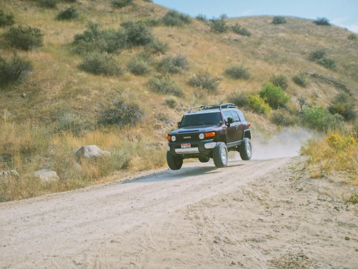 the four wheel drive jeep is on a dirt road