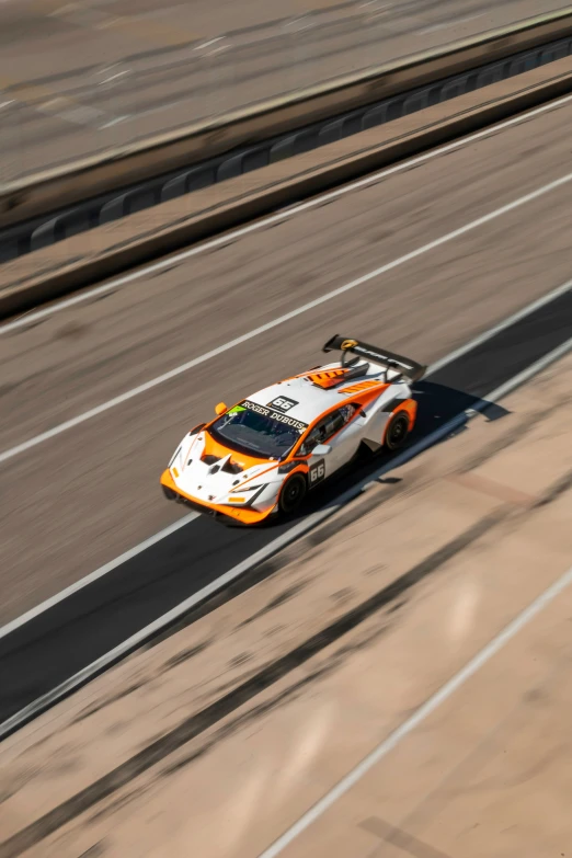 the man in the orange and white race car is on the road