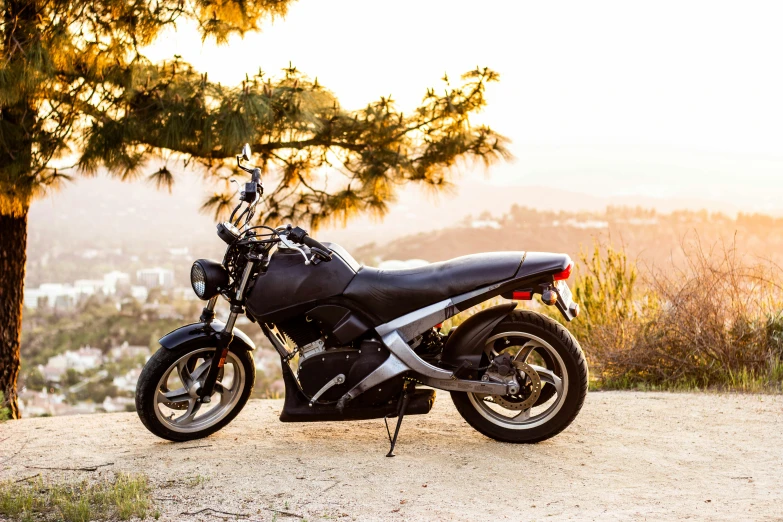 black motorcycle on dirt road with sun shining through