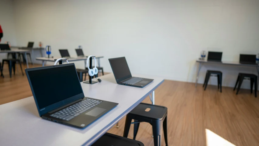 two lap top computers sitting on a white table