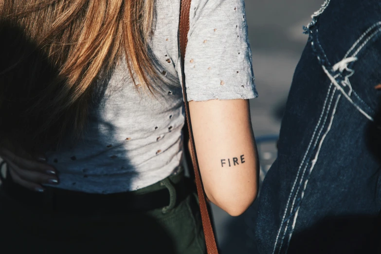 a woman with tattoos that read fine