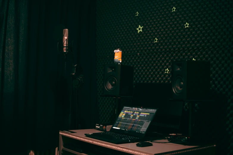 a laptop sitting on a desk with speakers and an array of lights in the background