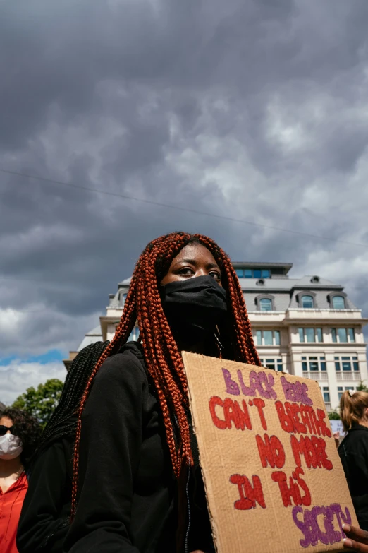 a woman wearing a black mask and dreadlocks