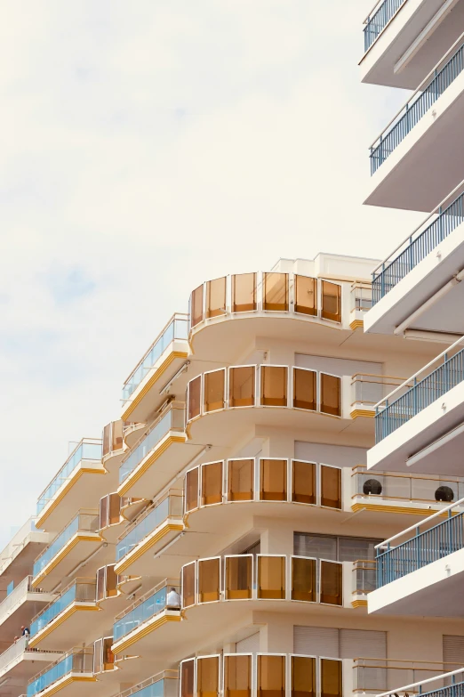 a tall white and beige building next to blue buildings