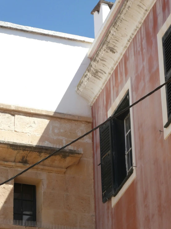 a bird perched on the corner of an old building