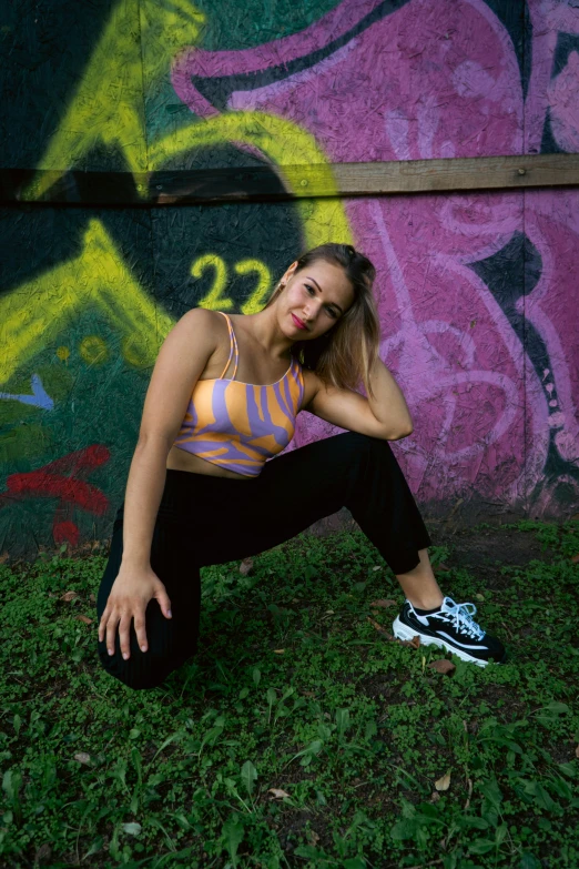 a girl is posing in front of graffiti