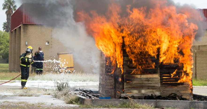 firefighters at a house fire next to their hoses