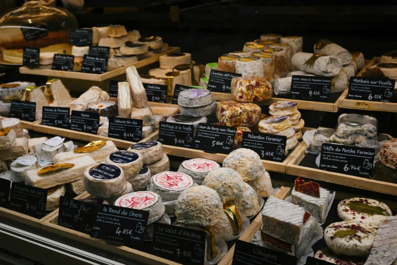 several types of breads and cheese on display in a grocery store