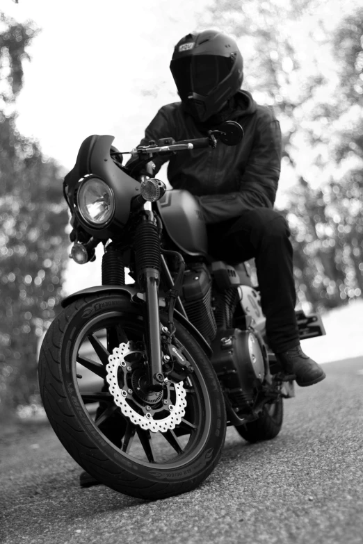 a person in black sitting on a motor bike