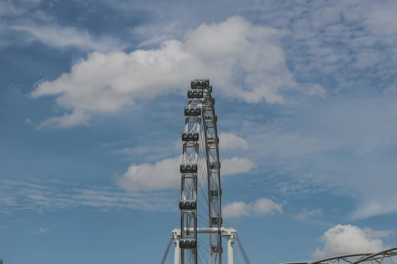 the ferris wheel at an amut park under blue sky with clouds