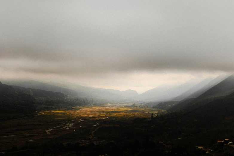 dark mountains with clouds and grassy area beneath them