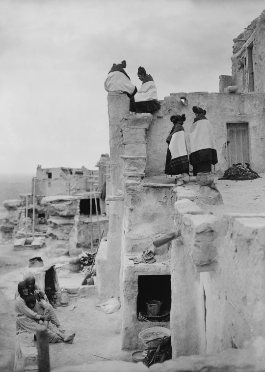 three men on top of the roof of an old stone building