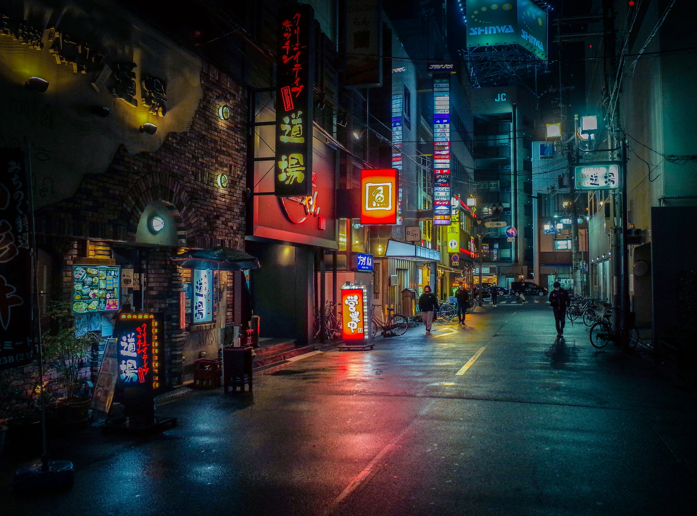the streets in a large city at night are filled with neon signs