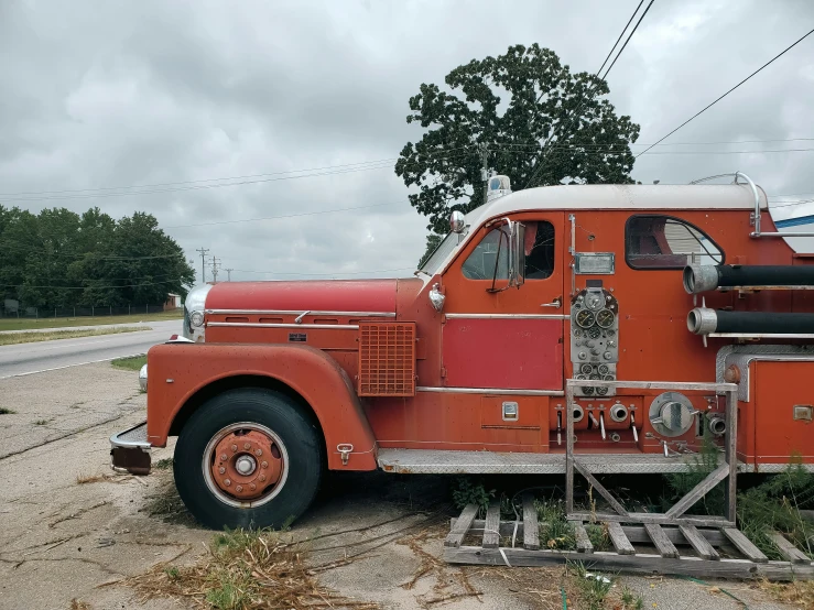 an old orange fire engine parked on the side of the road