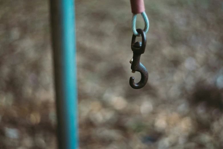 a pair of metal chains hanging from a wooden post