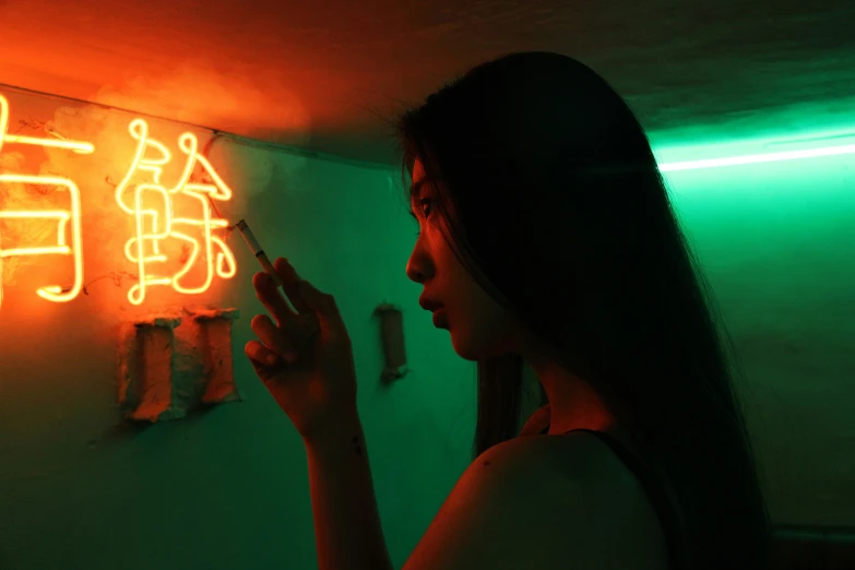 a woman using a cell phone near a neon sign