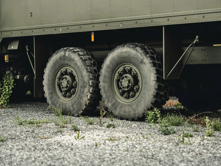 a truck with two large tires sitting on top of gravel