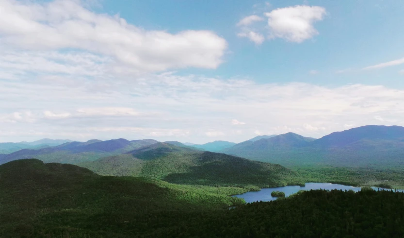 the view from top of a mountain over a lake and mountain range