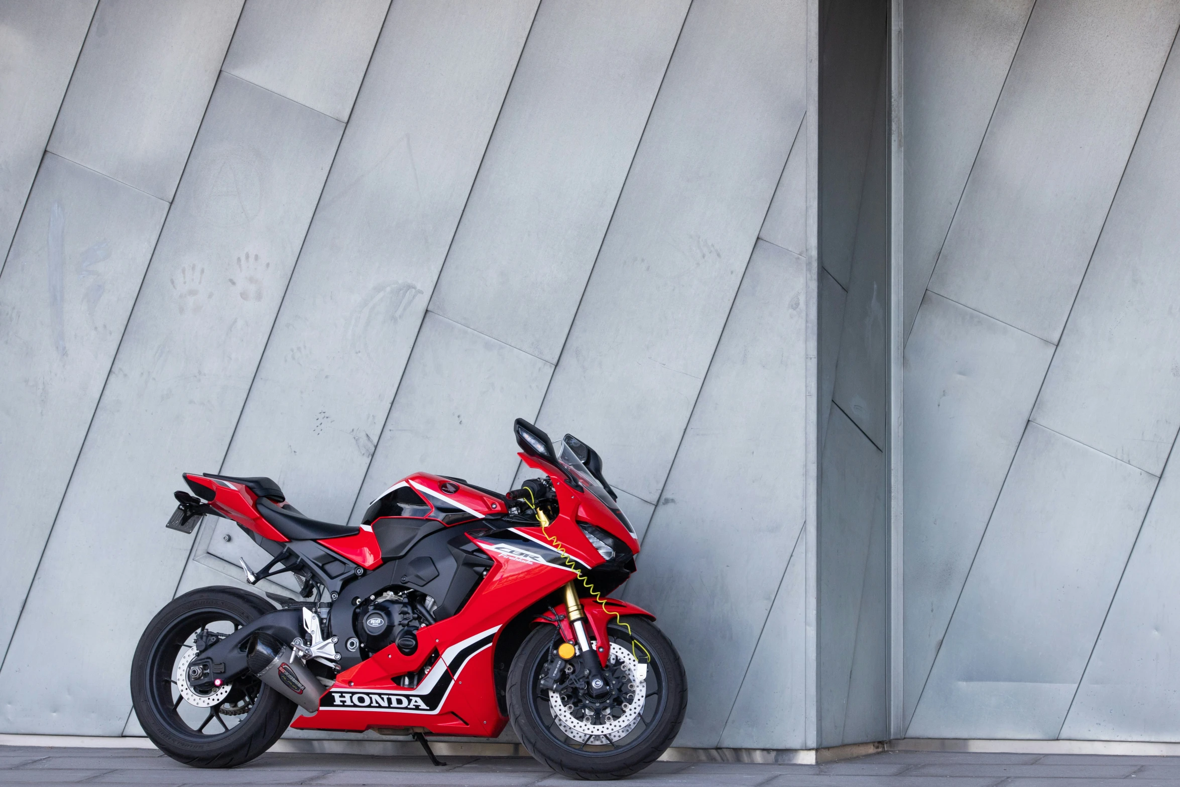 a motorcycle parked next to a grey wall