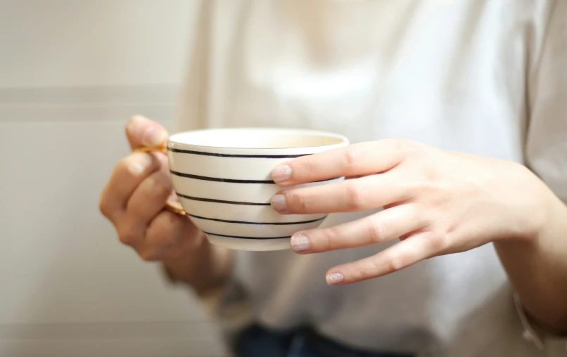 a woman holding a cup with her hands