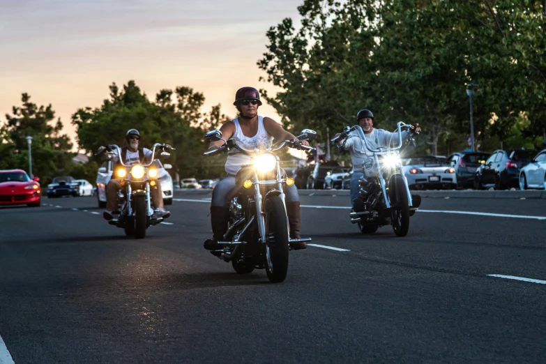 several people riding motorcycles down a street with one person on the front