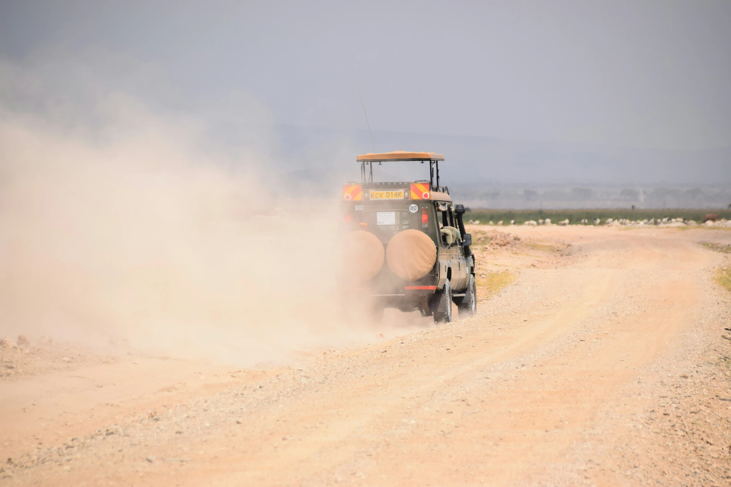 a dump truck driving down a dirt road