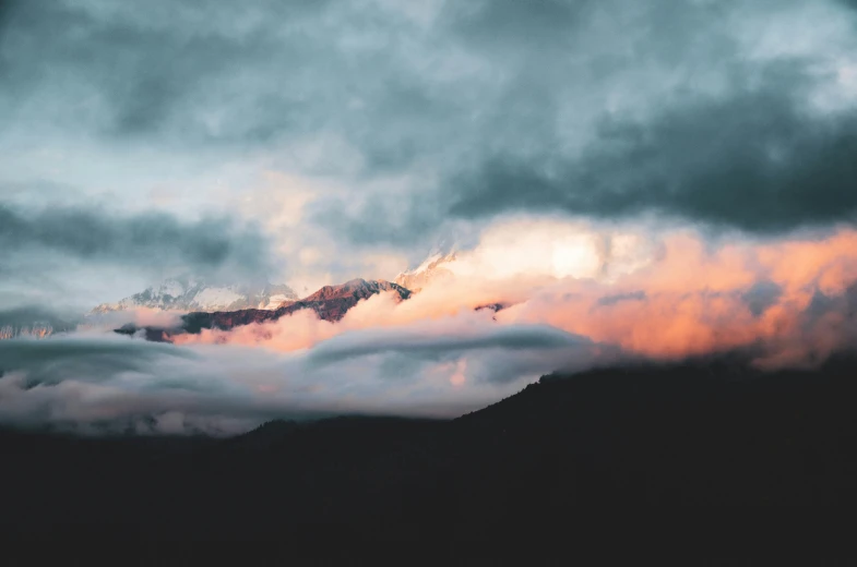 sunset clouds rolling in over a mountain range