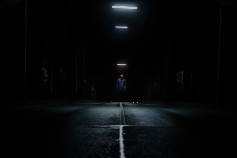 a man standing in a dark area alone