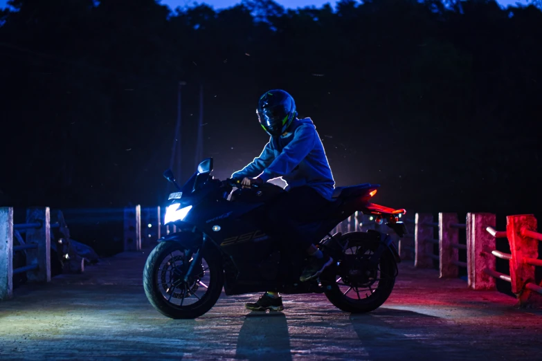 the rider on a motorcycle sits in front of a gated area