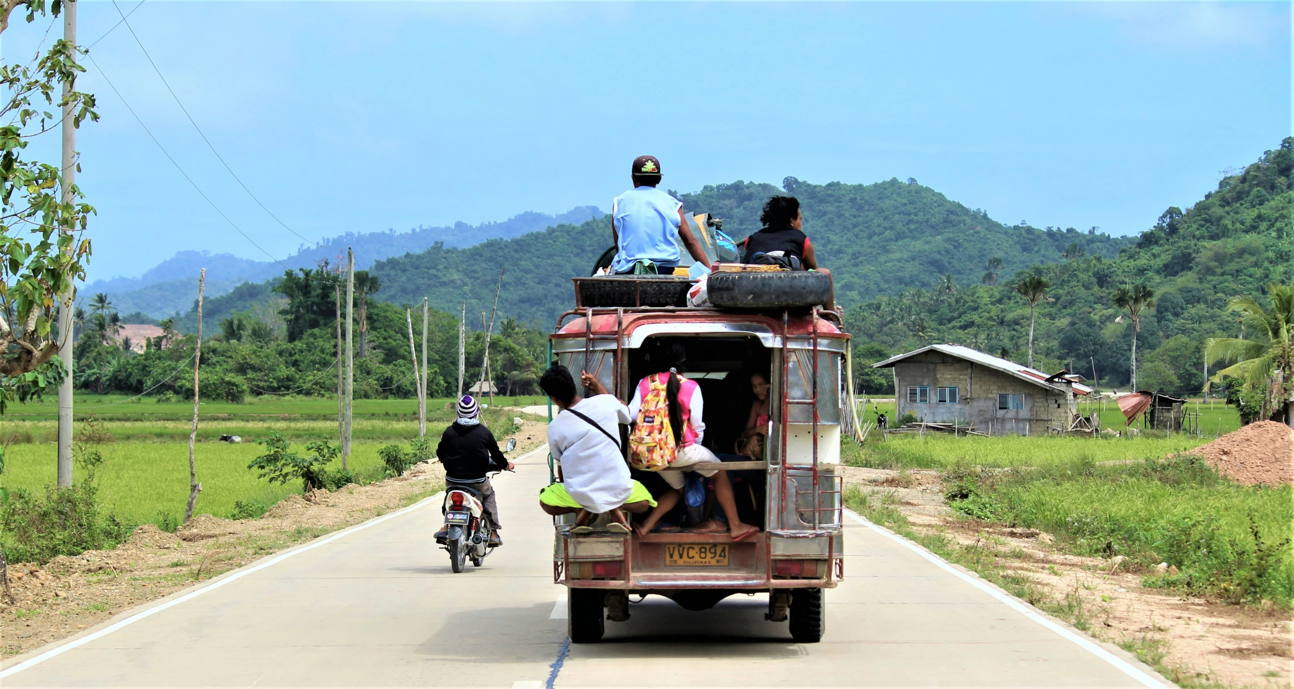 several people on the back of a rickshaw with luggage on their backs