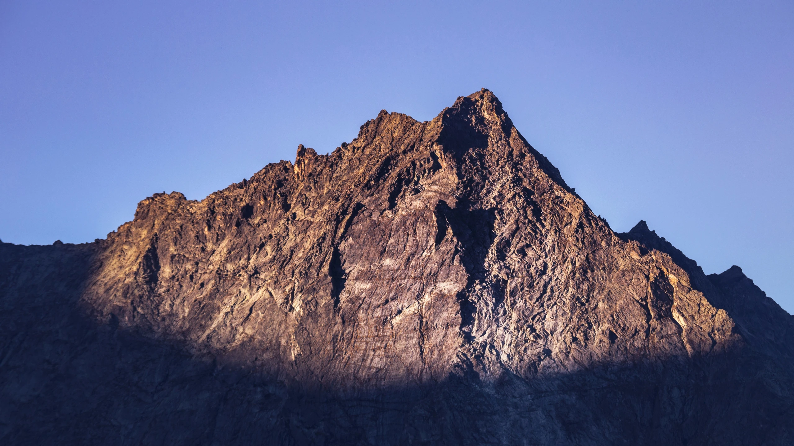 the top of a large mountain with a dark peak