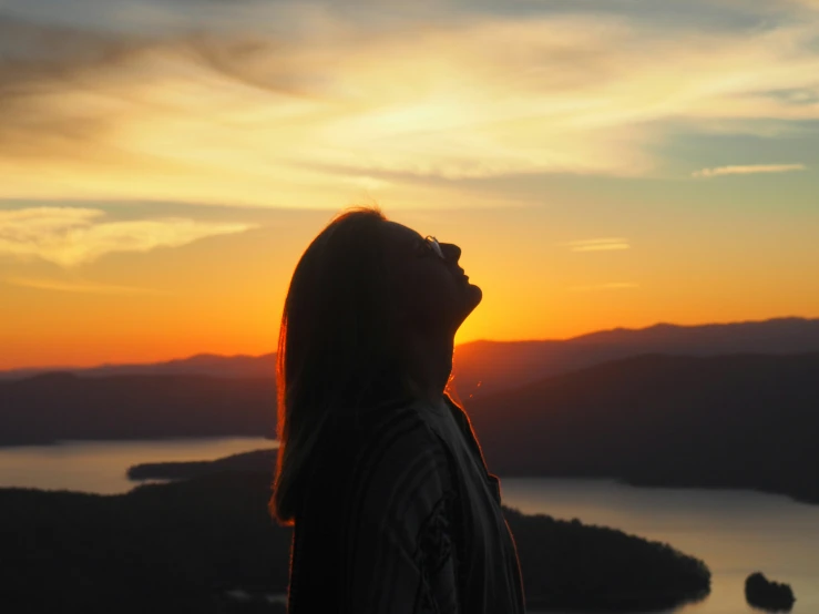 the silhouette of a person against a setting sun