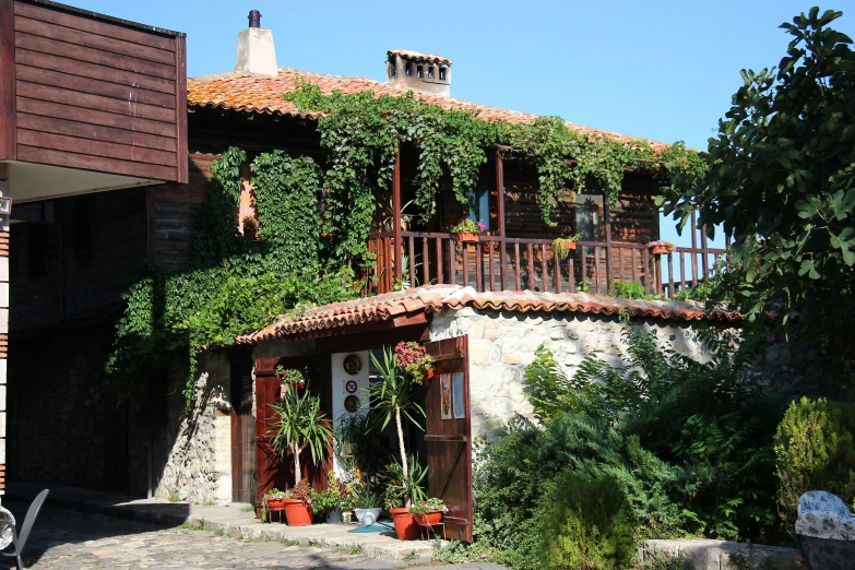 a large house with a balcony covered in vines