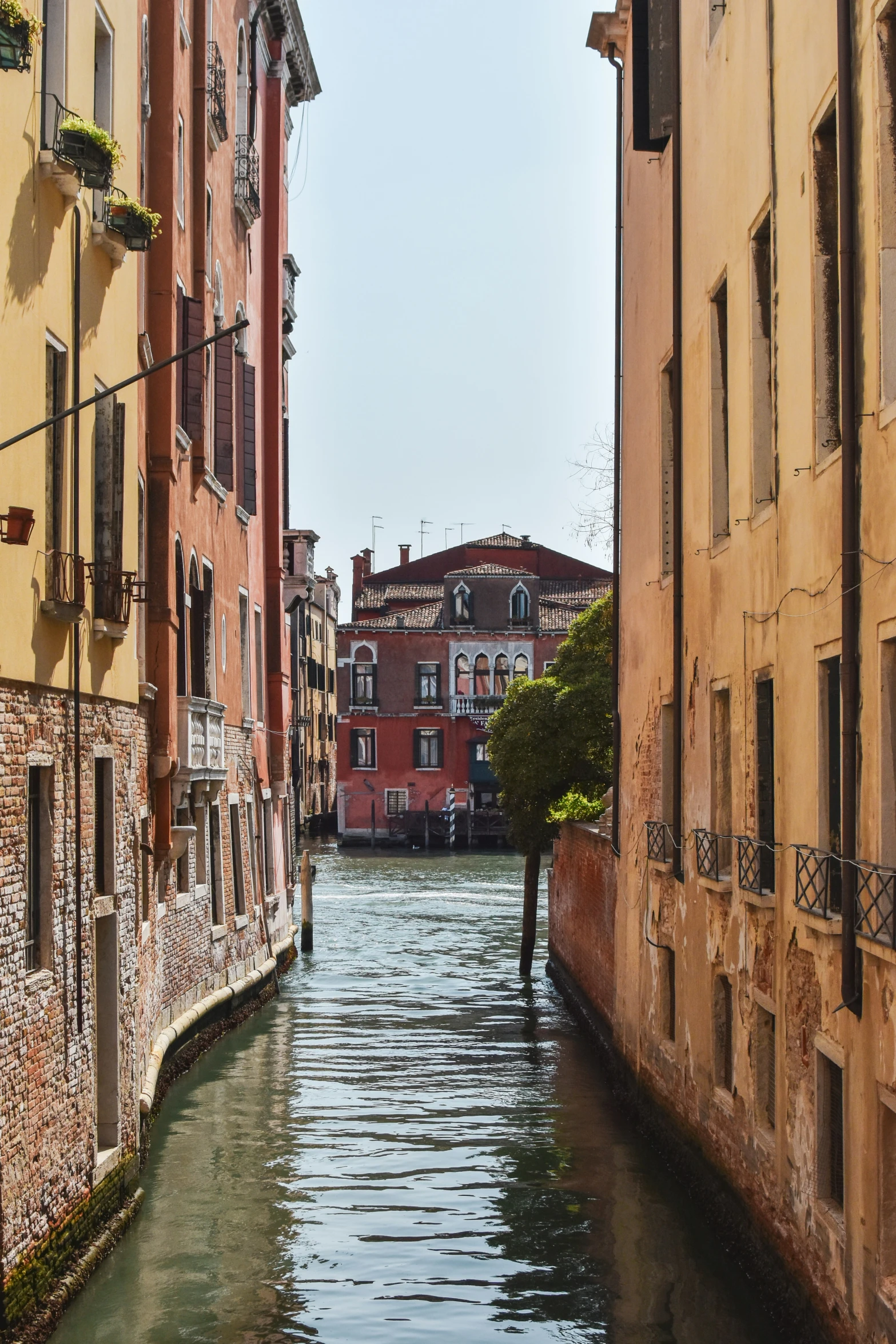 a narrow river flowing between two buildings in an old town