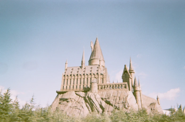 a large castle surrounded by trees on top of a hill