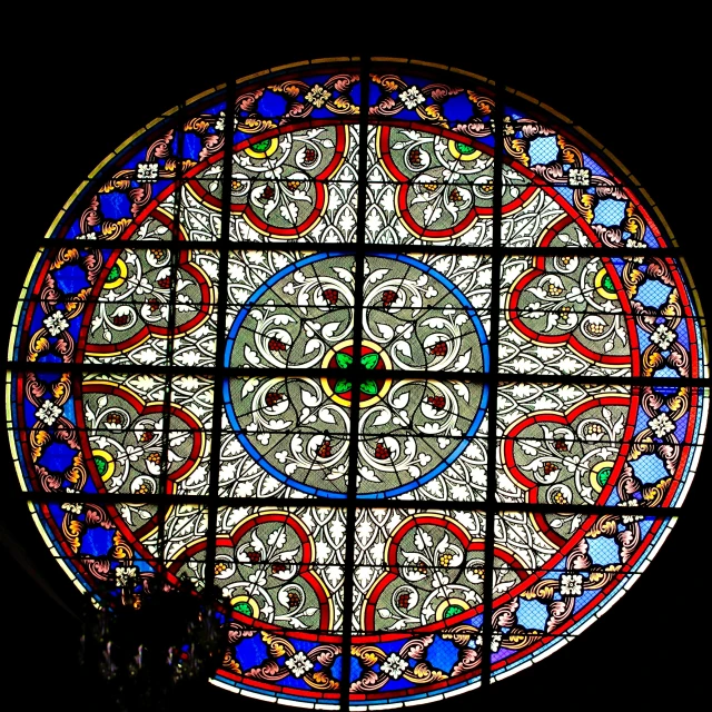 the circular stained glass window is decorated with ornate designs