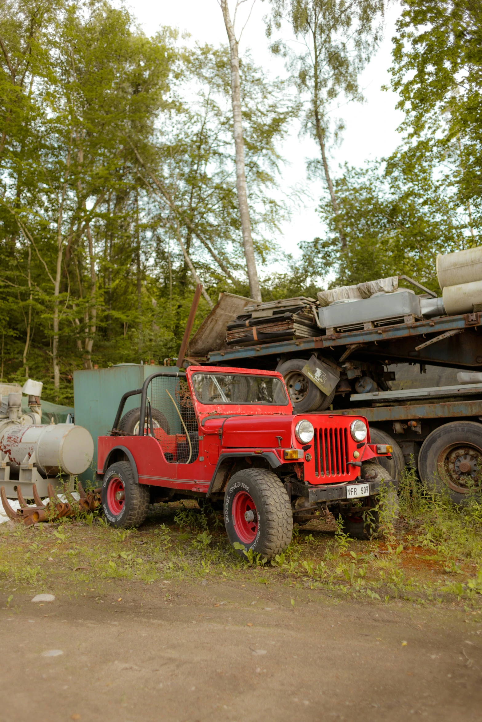 there is an old red truck sitting by a trailer