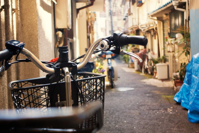 a bicycle with its front basket is parked in a street