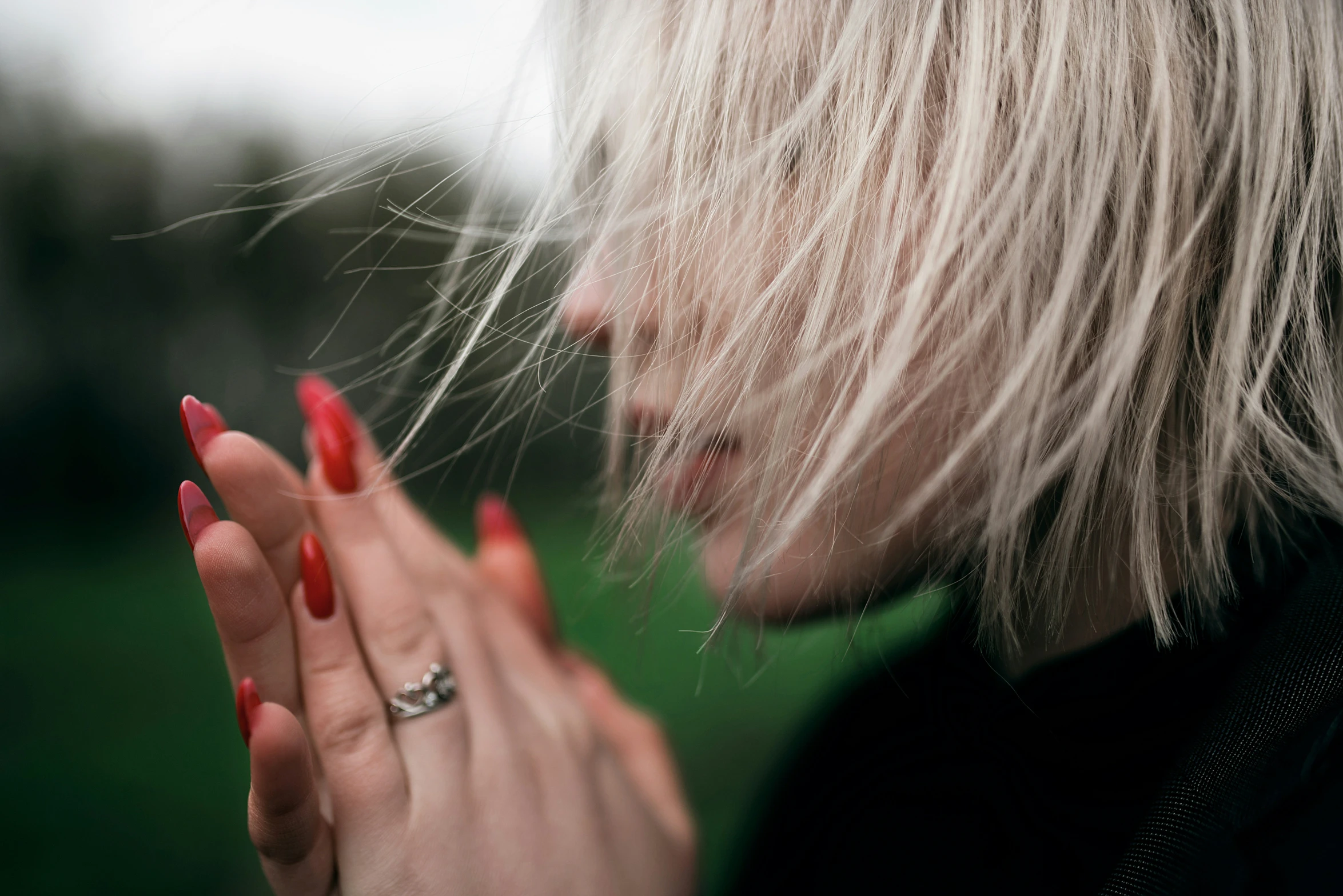 a woman with red nails and rings in the wind