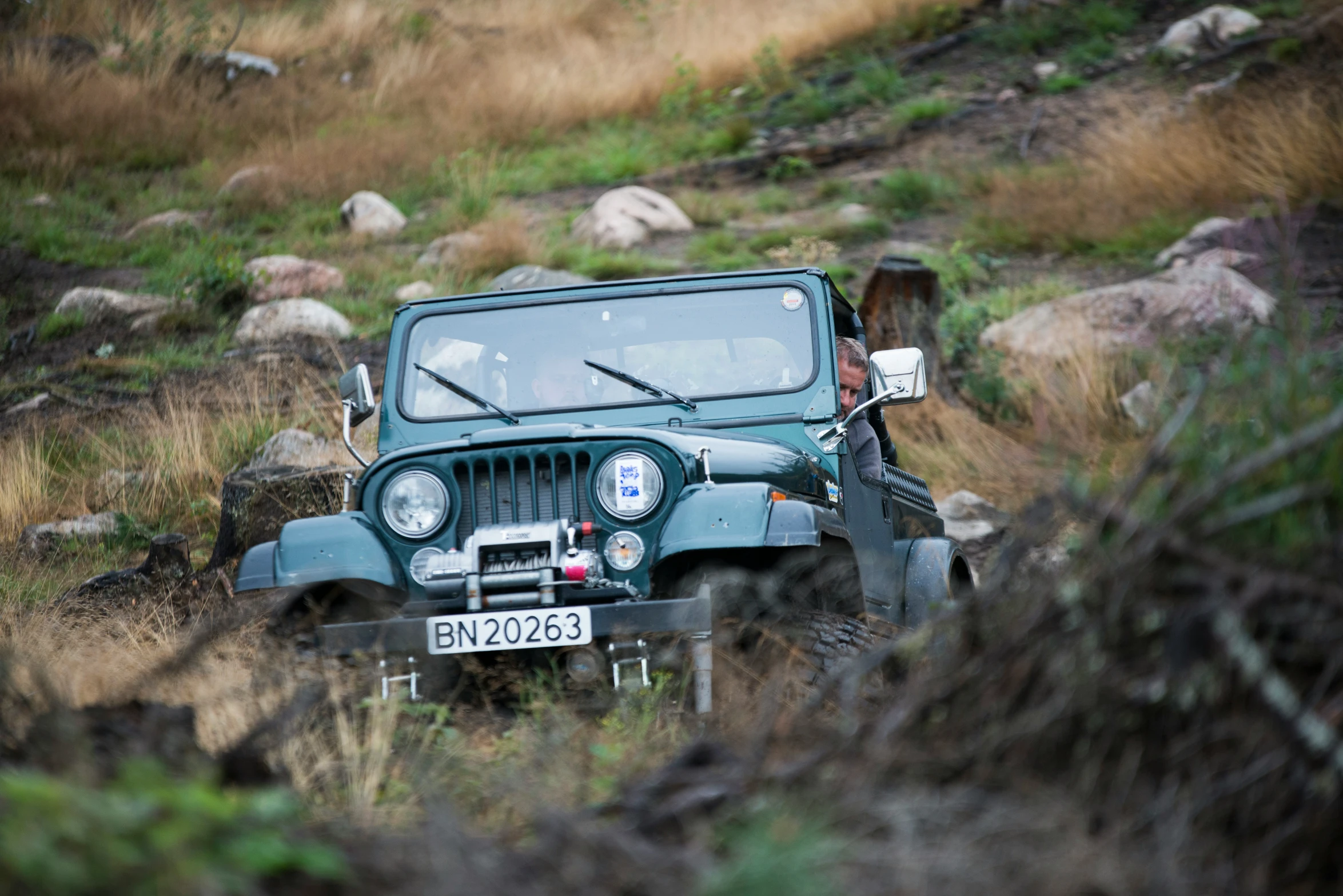 an old jeep is in the middle of the field