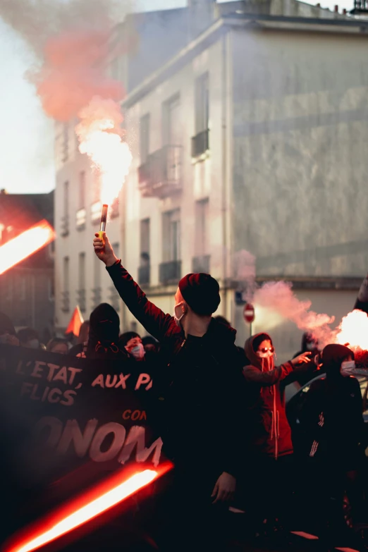 a large group of people holding flarers in the street