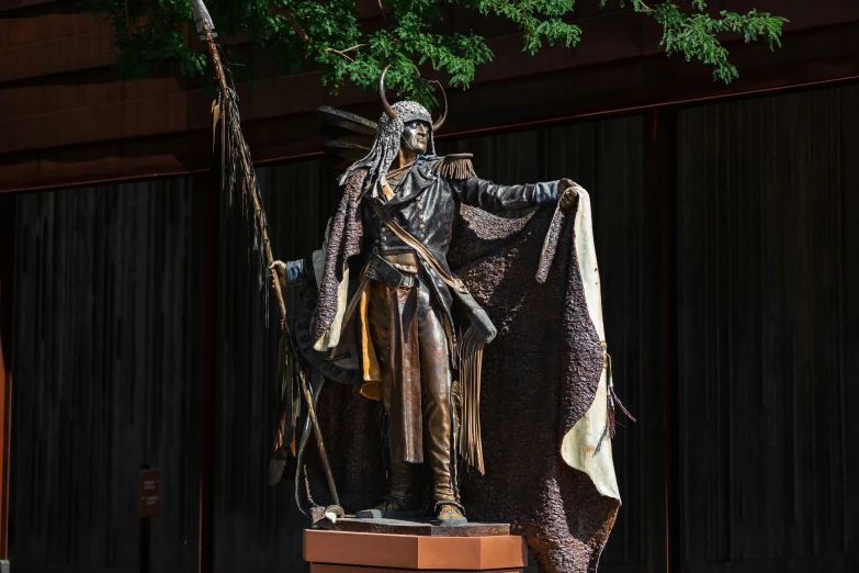 a statue of an indian woman standing in front of a building