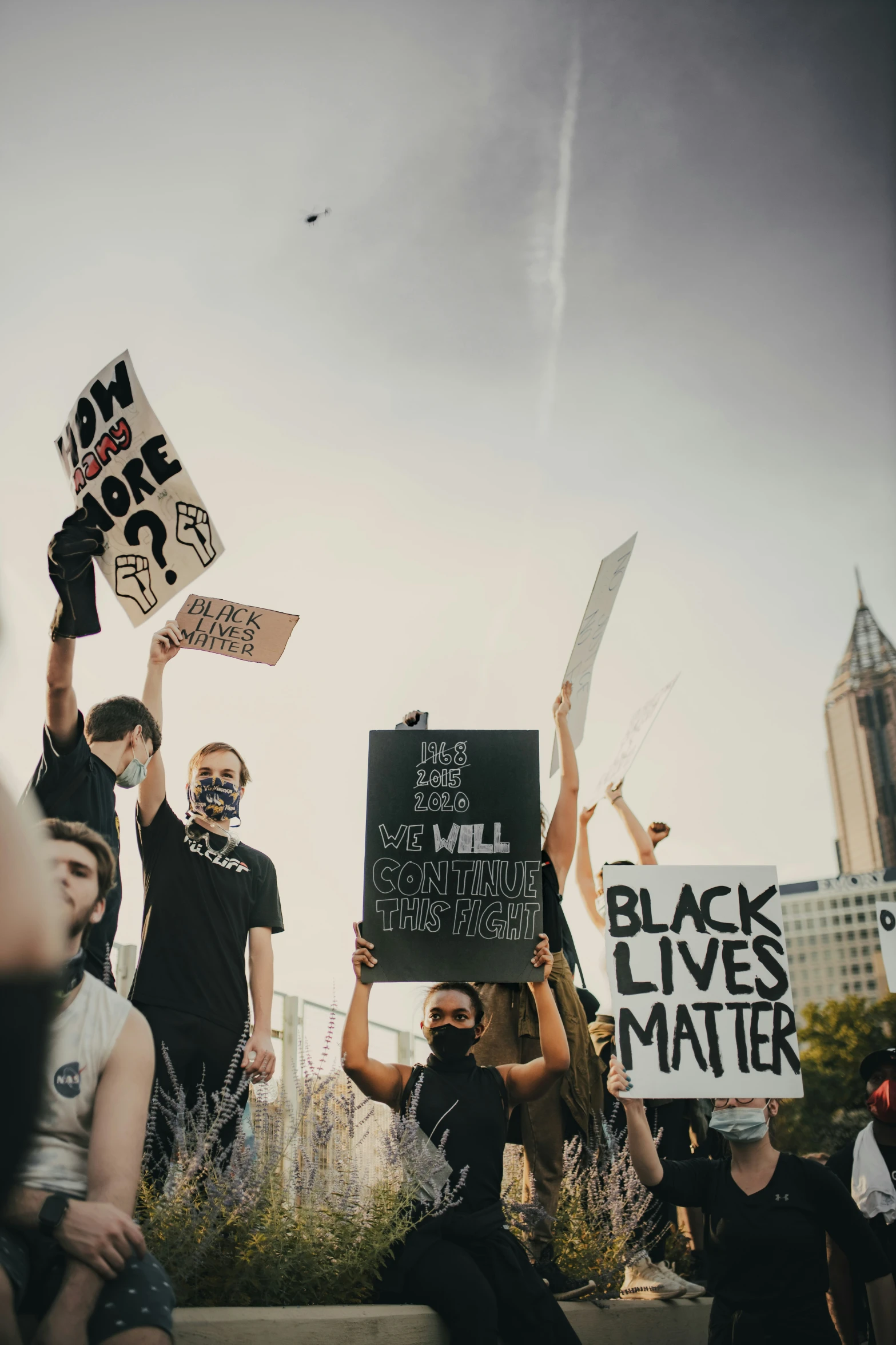 protesters are holding signs on their faces and posing