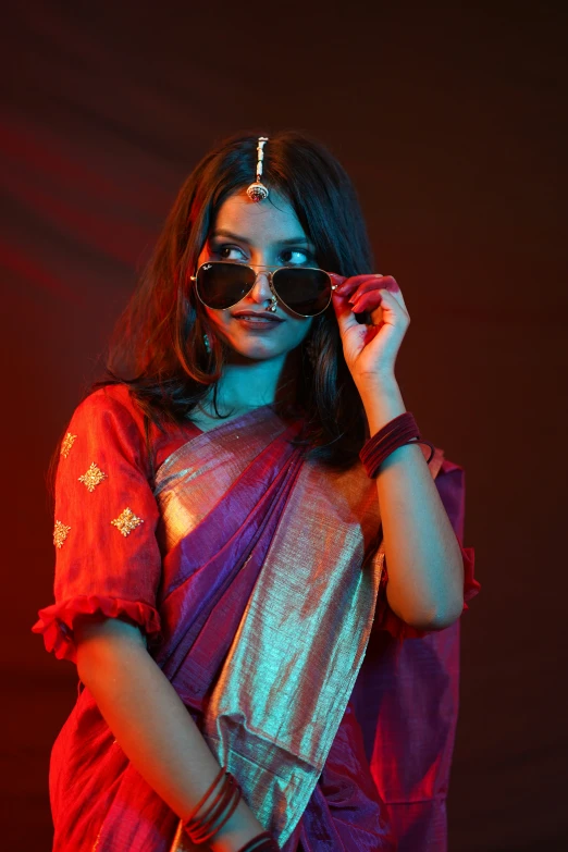 a woman in sunglasses and a sari with a pink border