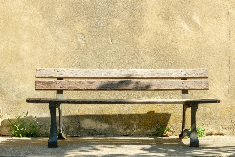 the park bench is next to the wall