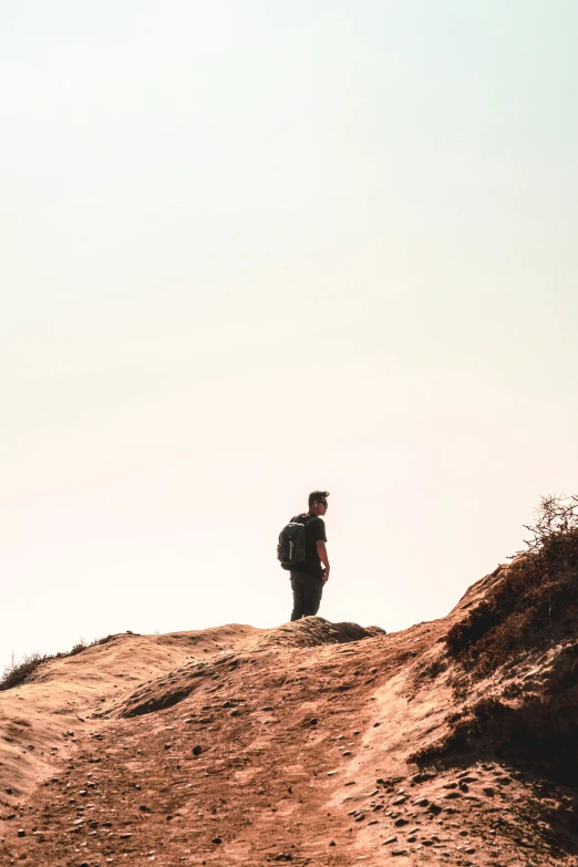 the man walks on top of a hill