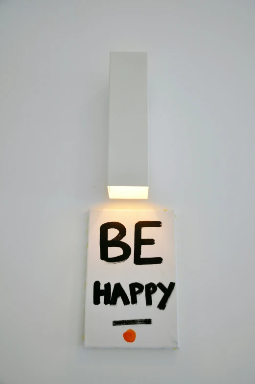 a white wall with the letters be happy written on it